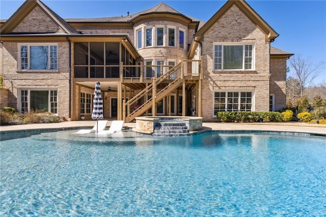 view of swimming pool with a patio, a pool with connected hot tub, a wooden deck, ceiling fan, and stairs