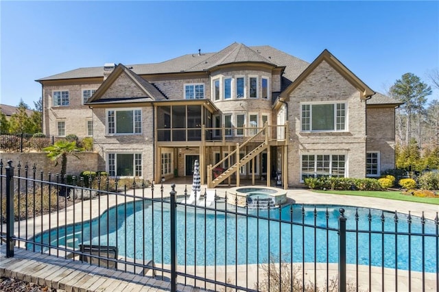 view of pool featuring a patio, a sunroom, a pool with connected hot tub, fence, and stairs