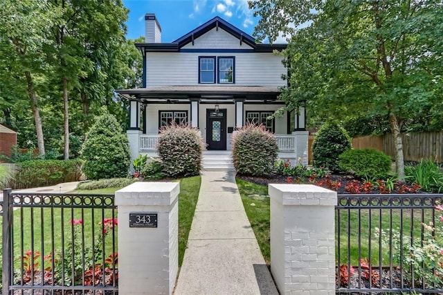 kitchen featuring high end appliances, white cabinetry, wall chimney range hood, dark hardwood / wood-style flooring, and light stone countertops