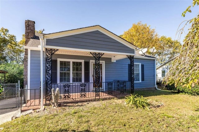 bungalow featuring covered porch and a front lawn