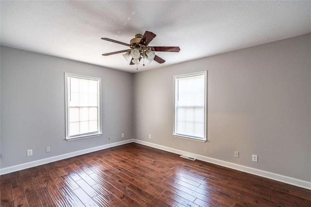 empty room with dark hardwood / wood-style floors, a textured ceiling, and ceiling fan