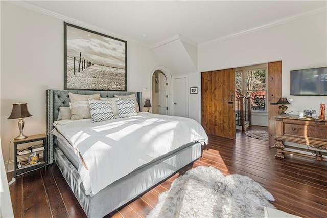 bedroom featuring arched walkways, wood-type flooring, and ornamental molding