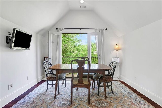 dining area with visible vents, lofted ceiling, baseboards, and wood finished floors