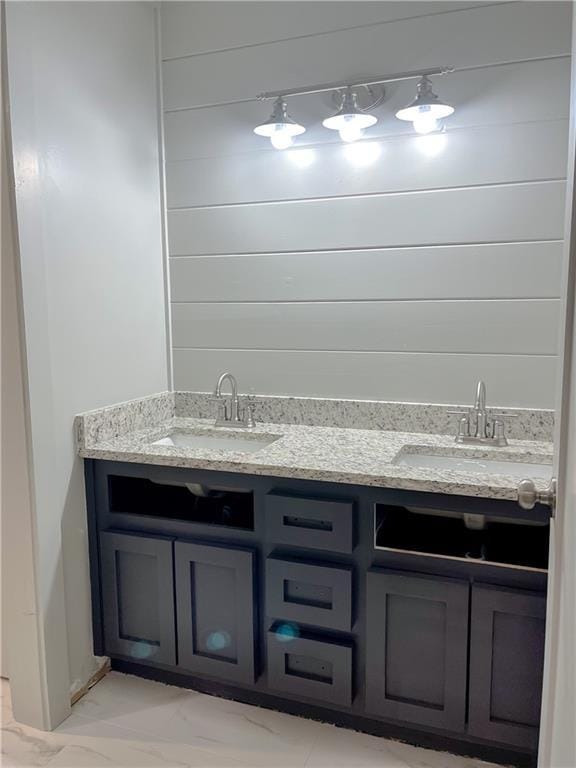 bathroom with vanity and wood walls