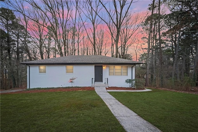 ranch-style home with a yard