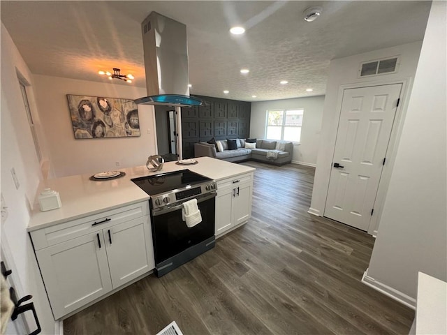 kitchen featuring white cabinets, dark wood-type flooring, island range hood, and stainless steel range with electric cooktop