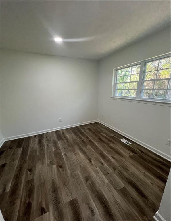 unfurnished room featuring dark wood-type flooring