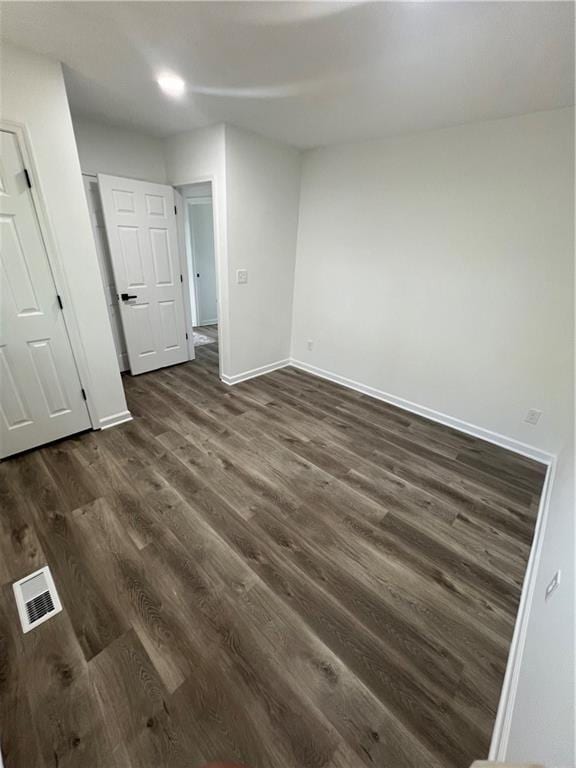 unfurnished room with dark wood-type flooring