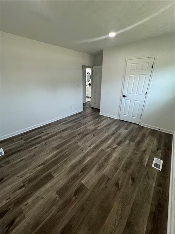 spare room with dark wood-type flooring