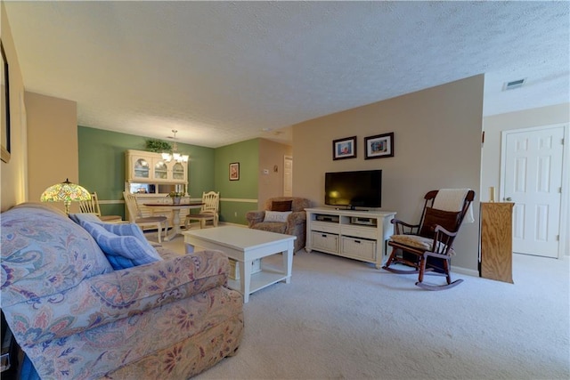 carpeted living room with a chandelier and a textured ceiling