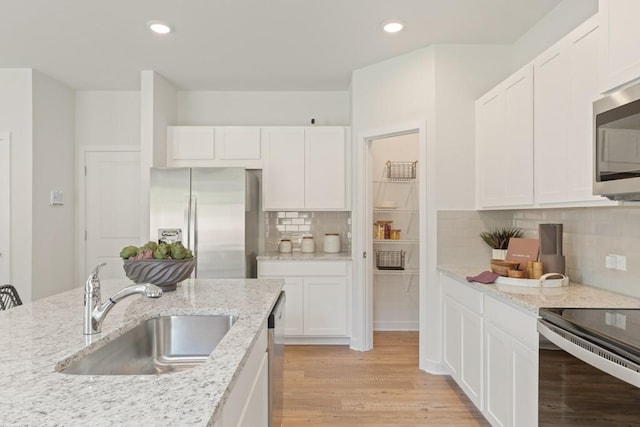 kitchen featuring stainless steel appliances, white cabinets, and a sink