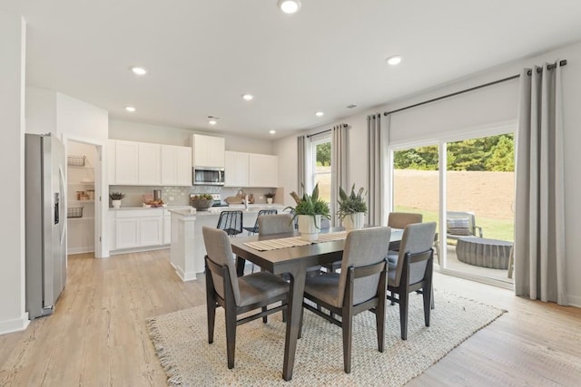 dining area featuring light wood-style flooring and recessed lighting