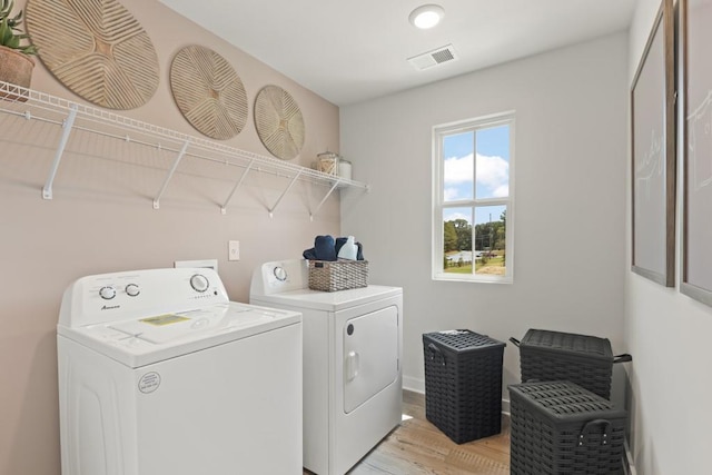 washroom featuring laundry area, visible vents, light wood-style floors, and washer and dryer