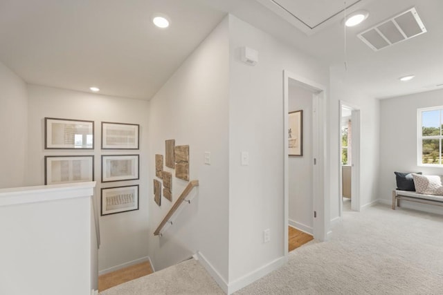 hallway with attic access, visible vents, an upstairs landing, carpet floors, and recessed lighting