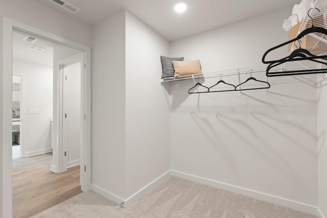 spacious closet featuring visible vents and light carpet