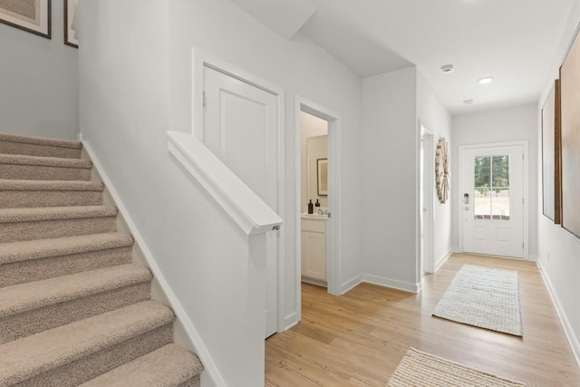 foyer entrance with recessed lighting, light wood-style flooring, baseboards, and stairs