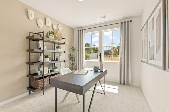 office space featuring light colored carpet, visible vents, and baseboards