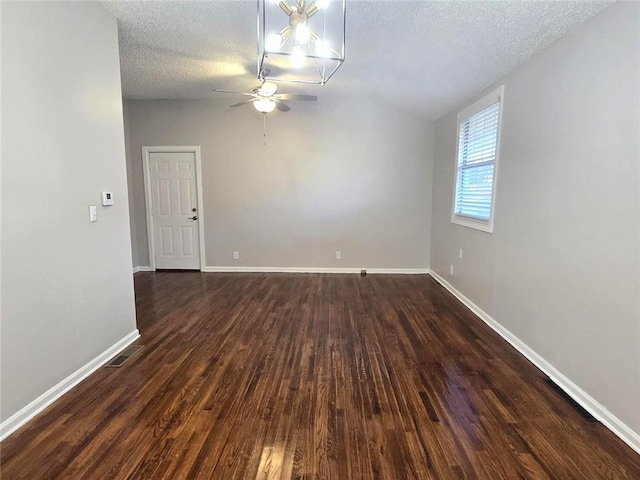 empty room with visible vents, dark wood-type flooring, ceiling fan, baseboards, and a textured ceiling