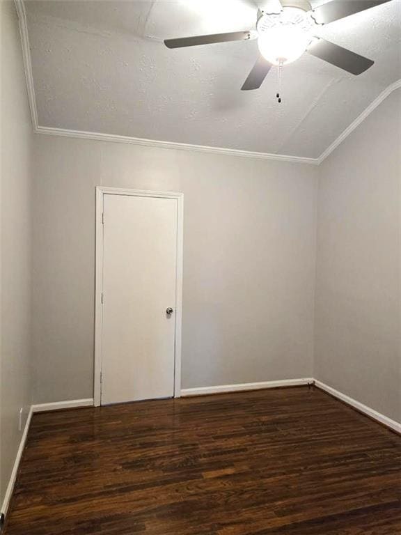 empty room with baseboards, wood finished floors, a ceiling fan, and vaulted ceiling