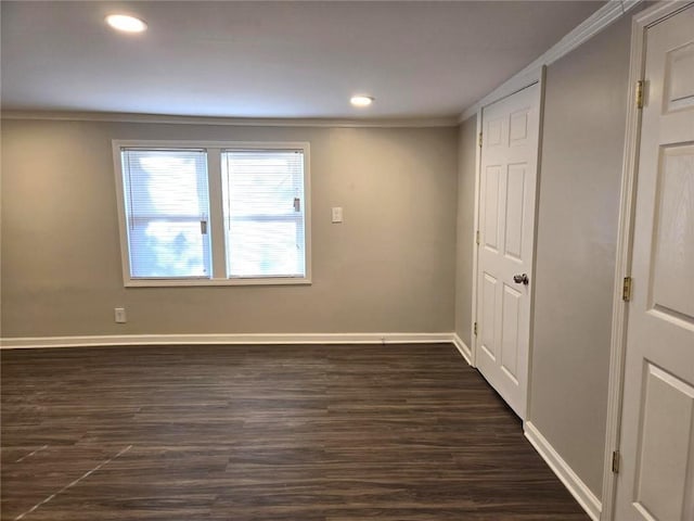 spare room featuring recessed lighting, crown molding, baseboards, and dark wood-style flooring