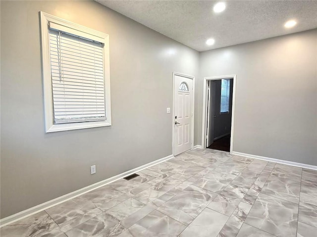 foyer with recessed lighting, visible vents, baseboards, and a textured ceiling