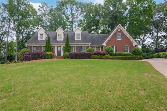 new england style home with brick siding and a front yard