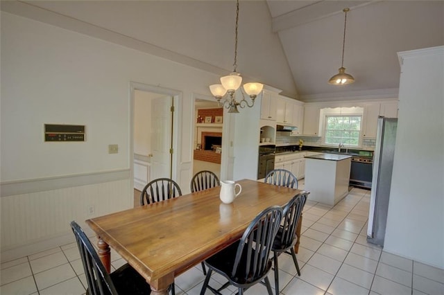 dining room featuring beam ceiling, light tile patterned floors, wainscoting, a chandelier, and high vaulted ceiling