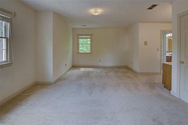 spare room with light colored carpet and baseboards