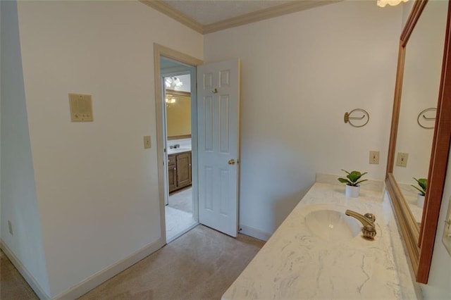 bathroom with baseboards, crown molding, and vanity