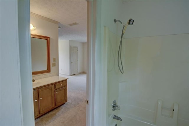 bathroom featuring a textured ceiling, washtub / shower combination, and vanity