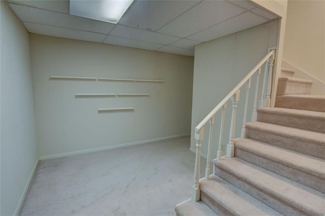 stairs with carpet floors, baseboards, and a paneled ceiling