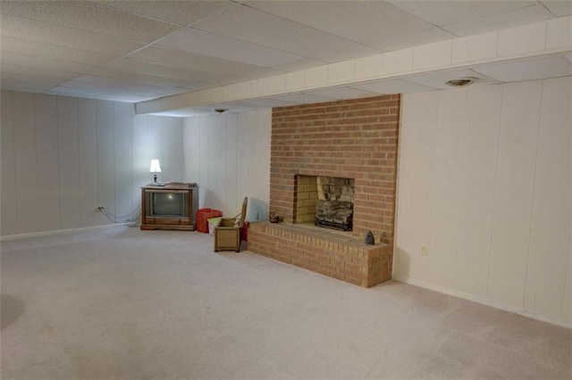 carpeted living area with a brick fireplace, baseboards, and a drop ceiling