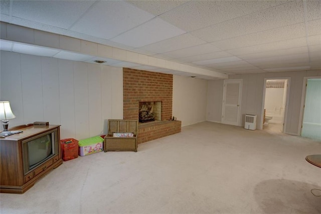 unfurnished living room featuring carpet flooring, a paneled ceiling, and a brick fireplace