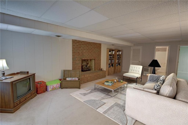 carpeted living room featuring a paneled ceiling and a fireplace