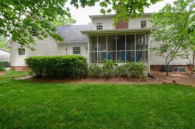 back of property featuring a yard, a sunroom, and central AC