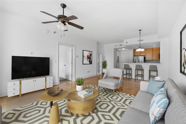 living room with light hardwood / wood-style floors and ceiling fan