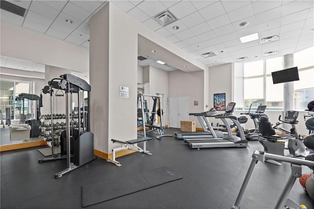 gym featuring a paneled ceiling and a high ceiling