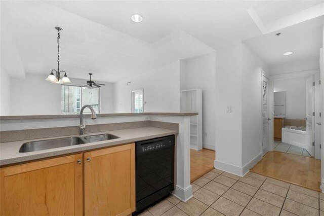 kitchen with dishwasher, sink, light tile patterned flooring, and light brown cabinetry