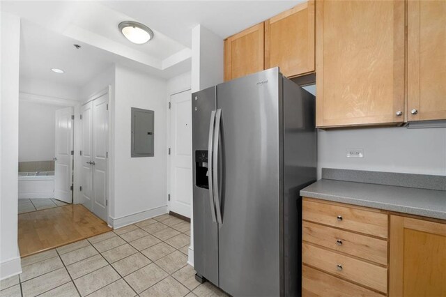 kitchen featuring light tile patterned floors, stainless steel fridge, and electric panel