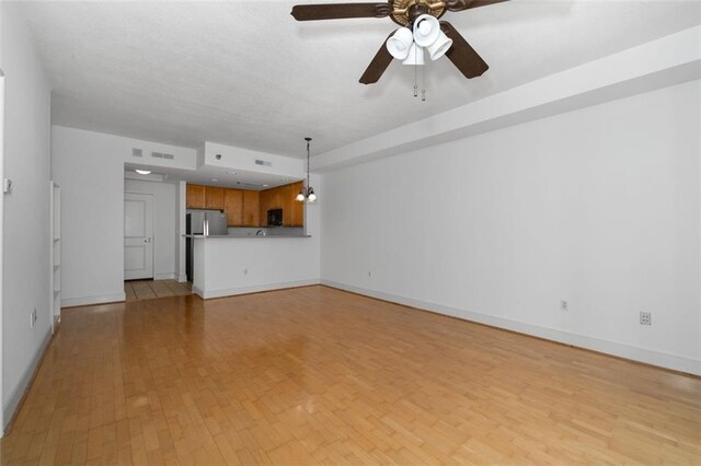 unfurnished living room with ceiling fan and light wood-type flooring