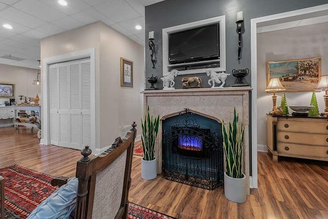 living room with wood-type flooring and a drop ceiling