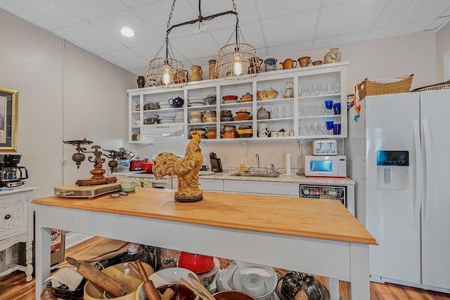 kitchen featuring sink, pendant lighting, white appliances, and a paneled ceiling