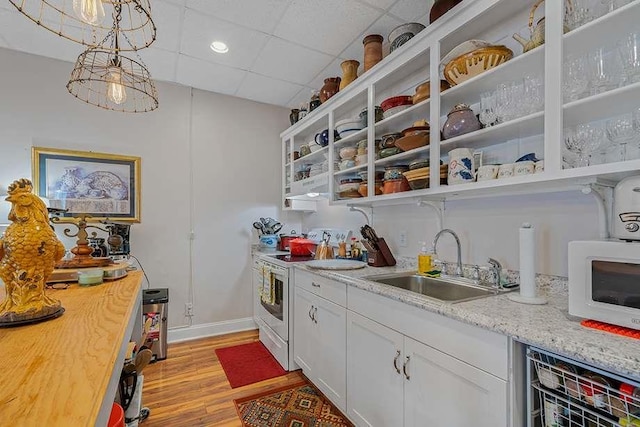 kitchen with decorative light fixtures, a drop ceiling, sink, white appliances, and white cabinetry