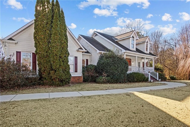 view of side of home with a porch and a yard