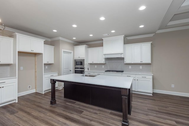 5587 Spring St, Flowery Branch, GA 30542 - kitchen featuring crown molding, stainless steel appliances, a center island with sink, and dark wood-style flooring