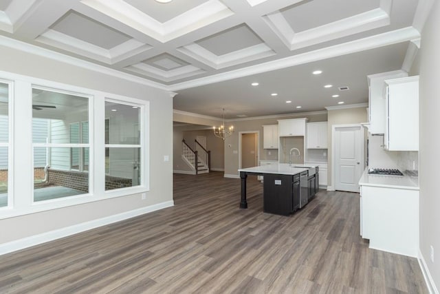 5587 Spring St, Flowery Branch, GA 30542 - kitchen with ornamental molding, a center island with sink, light countertops, a chandelier, and a sink