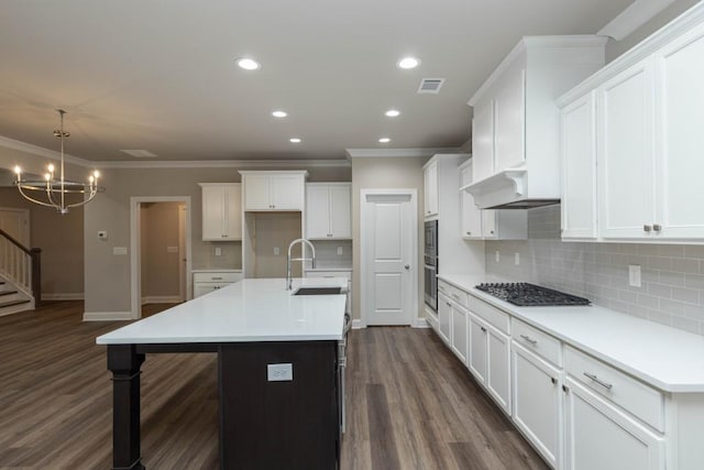 5587 Spring St, Flowery Branch, GA 30542 - kitchen with ornamental molding, stainless steel gas cooktop, under cabinet range hood, a sink, and a notable chandelier