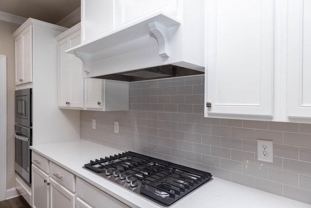 5587 Spring St, Flowery Branch, GA 30542 - kitchen featuring wall chimney range hood, light countertops, white cabinets, and stainless steel appliances