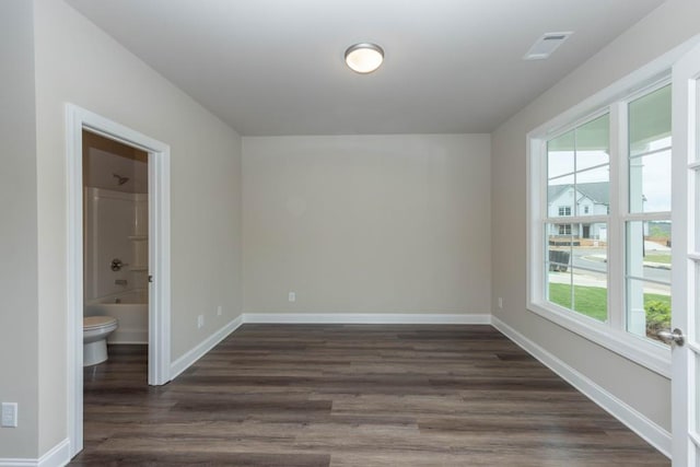 5587 Spring St, Flowery Branch, GA 30542 - empty room featuring dark wood-style flooring, baseboards, visible vents, and plenty of natural light