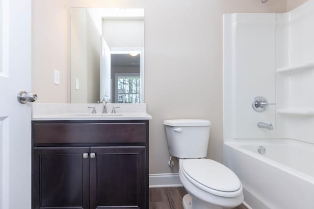 5587 Spring St, Flowery Branch, GA 30542 - bathroom featuring wood finished floors, baseboards, vanity, toilet, and bathing tub / shower combination